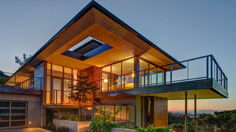A contemporary home accented by Feeney Cable Rail during dusk.