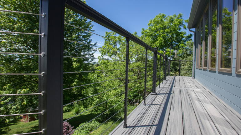 A 2nd-story deck made of IPE overlooks the water with an uninterrupted view thanks to Feeney CableRail Cable Railing