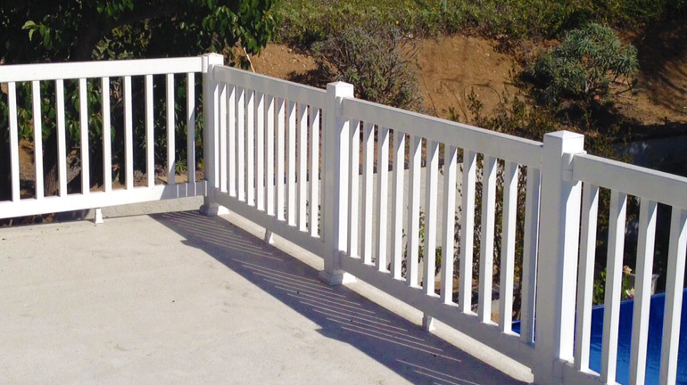 Manchester Railing by Durables in White borders a front porch.