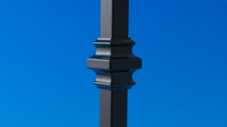 Black Collar Accessory by Deckorators installed on a square black baluster infront of a blue background.