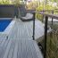Water damage and rot resistant, Barrette Siesta Grooved Edge Deck Boards, shown in Garapa Gray, beautifully frame a pool area.