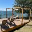 An extended LINX pergola overlooking a bright, sunny lake