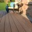 Emphasize the variety of colors within your brick home with TimberTech PVC Vintage Deck Boards in Dark Hickory.