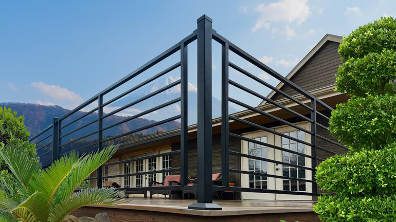 The corner of a deck flanked by the stylish horizontal look of Fortress FE26 Axis Railing