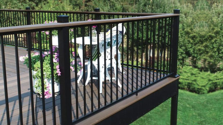 A deck surrounded by AL13 Home aluminum railing in matte black on a sunny day.