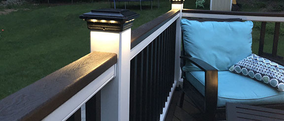 Solar Post Cap Light for Trex Transcend Post Sleeves by Ultra Bright on a Trex Railing with a comfy outdoor chair