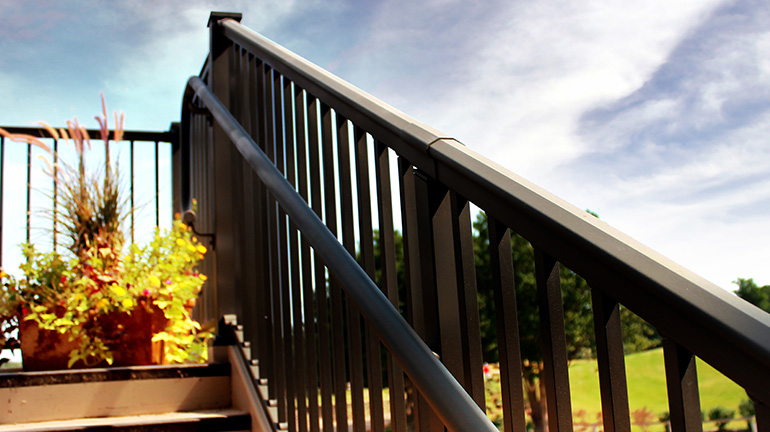 The rounded, traditional top rail of AFCO Pro Aluminum Deck Railing