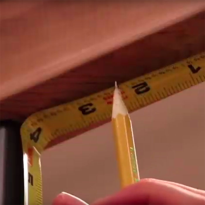 a closeup of a pencil marking a railing where the rail light will be installed