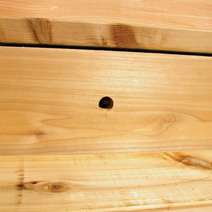 Photo of hole drilled in riser for stair light installation