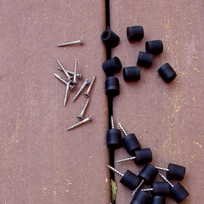 a pile of baluster connectors and screws laying on a deck