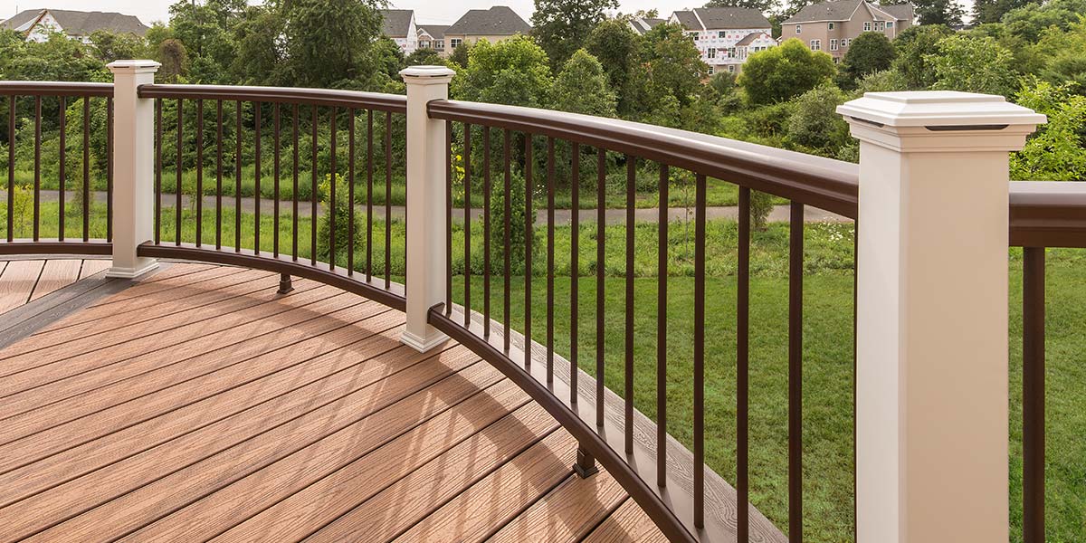 A round deck with Trex Transcend Composite Deck Railing with brown rails, black balusters, and white posts