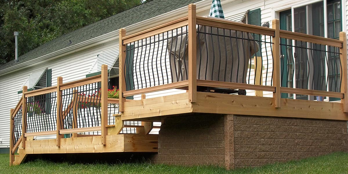 A Vista wood deck railing kit with distinctive curved balusters on a two-level deck
