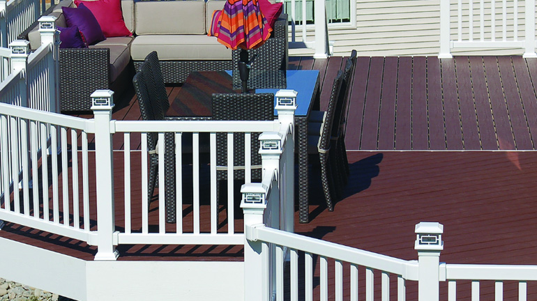 Vinyl Railing on a large composite backyard deck features white Orion Post Cap Lights from Aurora Deck Lighting
