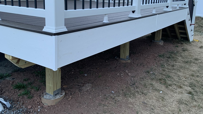 Trex Woodgrain White Fascia Boards on the corner of a new deck, using fascia guard trim pieces to cover over the seams for a polished finish