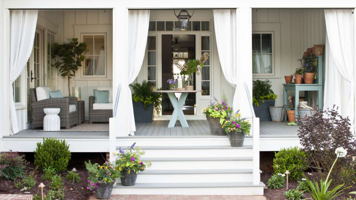 A gorgeous modern farmhouse front porch with curtains
