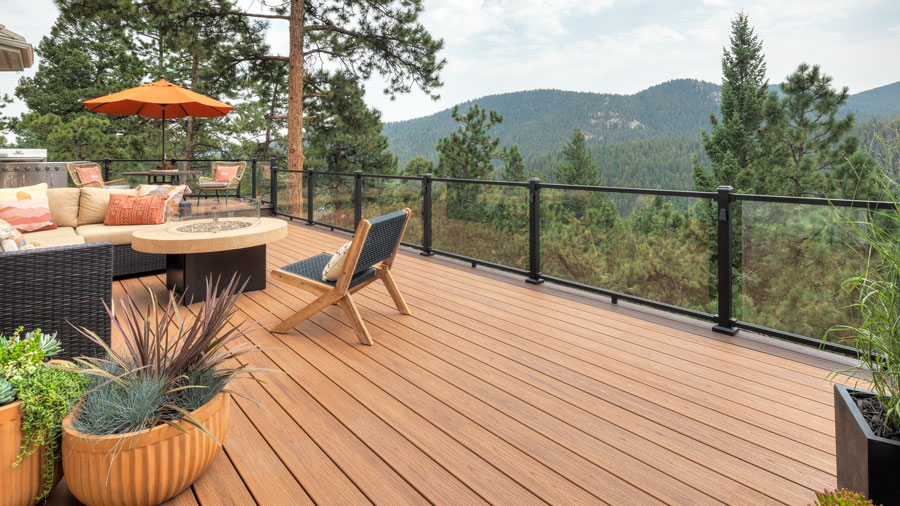 A glass deck railing overlooking a lush forest