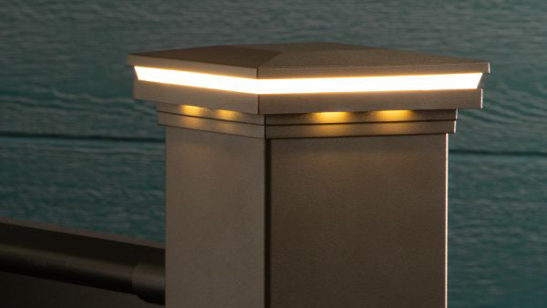 A lighted post cap on a bronze AFCO railing