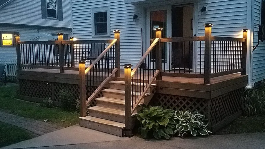 A set of deck stairs lit up by warm, inviting deck lights