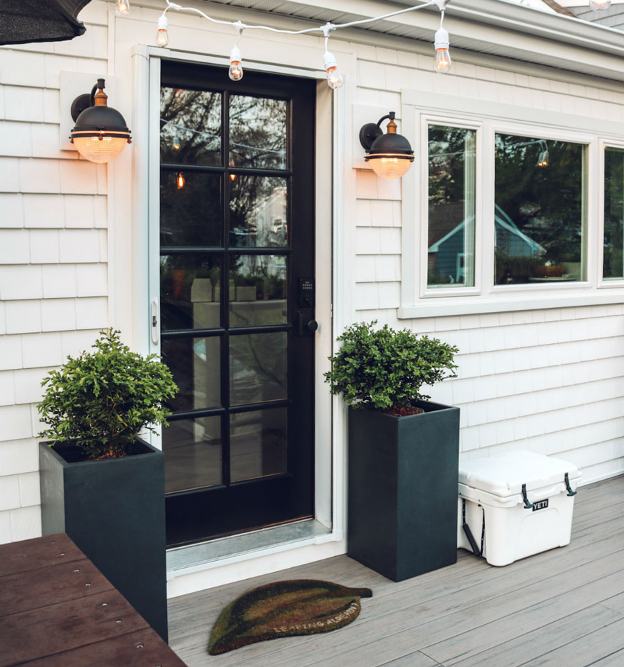 An inviting modern farmhouse porch door in black with white trim, plus farmhouse-style deck boards