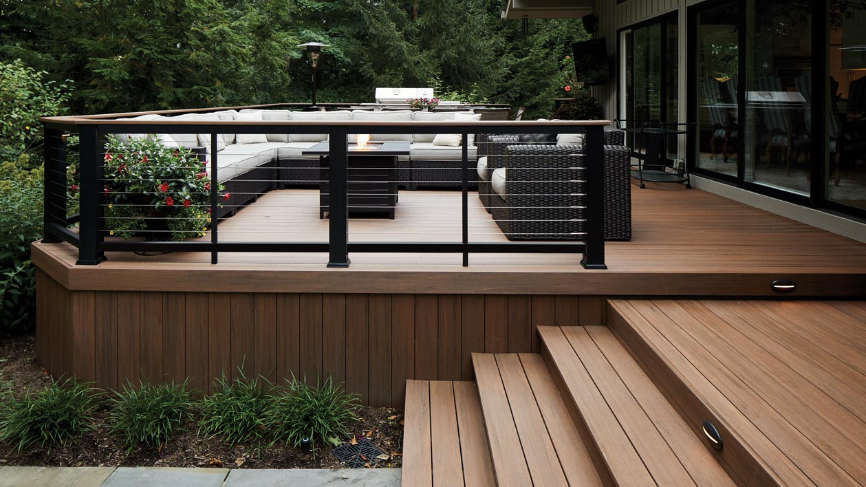 A unique-looking black composite deck railing with stainless steel cable runs