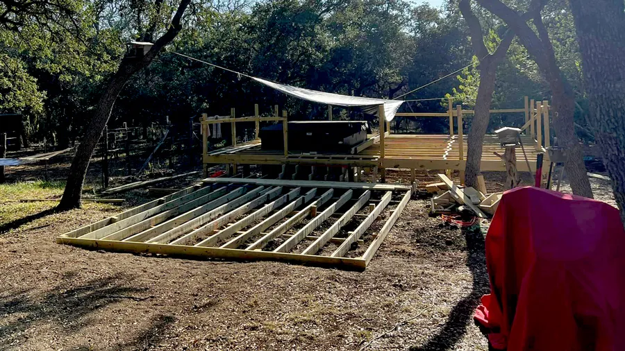 A wood deck frame built around a swim spa in a back yard