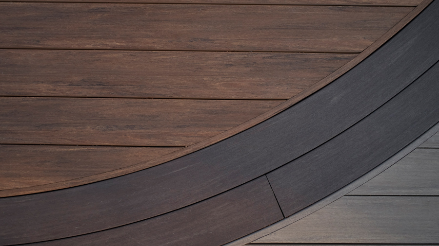 A deck featuring three different colors of deck boards: brown, dark gray, and light gray