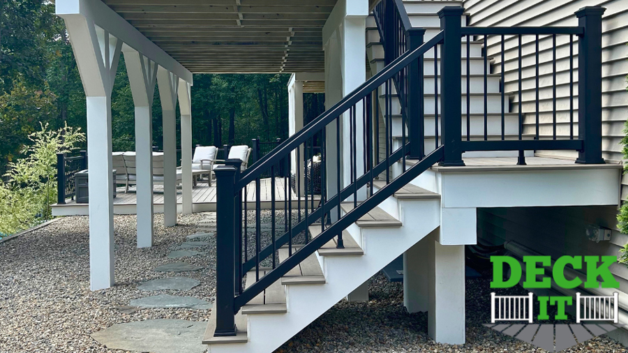 A set of deck stairs with black composite railing and bright white fascia and stair treads