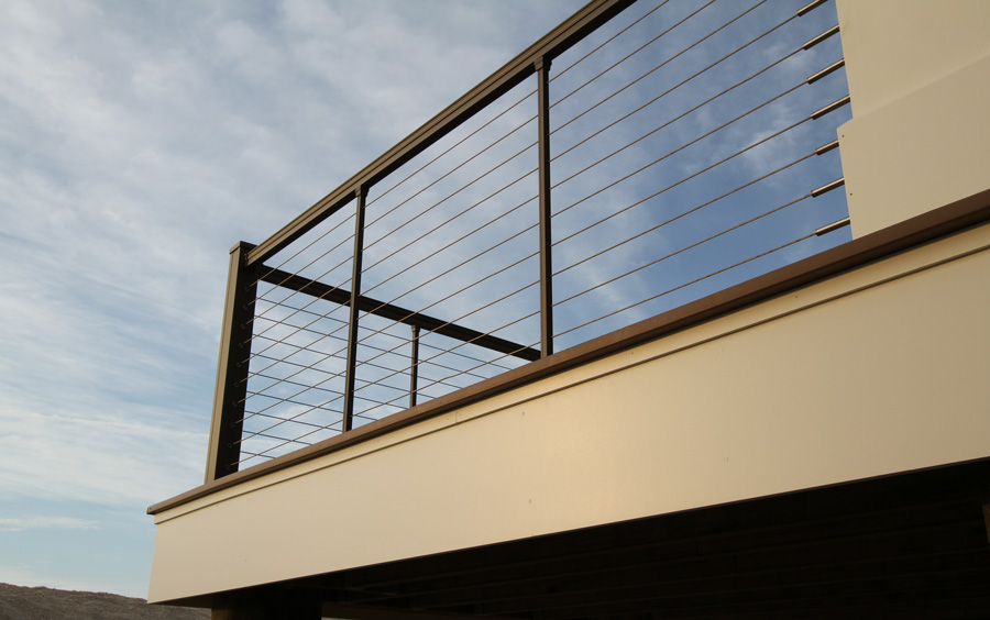 A metal railing with stainless steel cables for infill