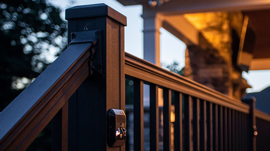 A craftsman-detailed metal deck railing under warm lights