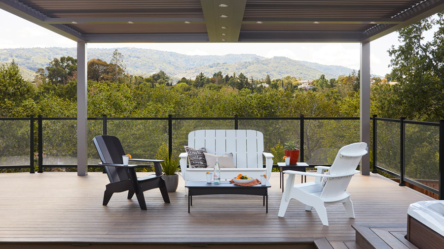 A mix of black and white TimberTech Outdoor Furniture sits on a deck under a pergola
