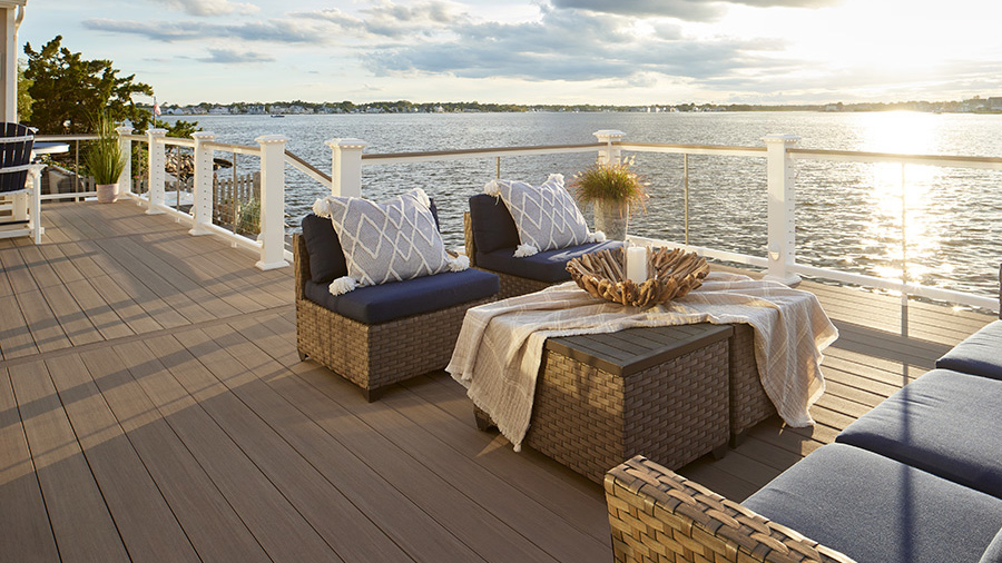 A picturesque deck in classic coastal style overlooking a lake at sunset