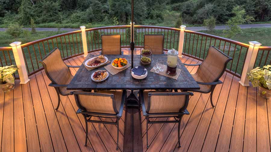 A deck set up for dinner atop a deck board pattern made from angled deck boards