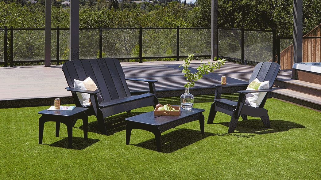 A set of TimberTech Invite Collection Outdoor Furniture sits on a manicured lawn near a pergola