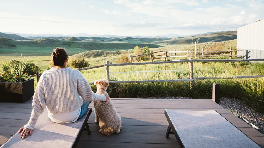 A dog and owner enjoy the sweeping view from a gorgeous pet-friendly deck