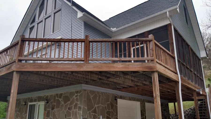 A wood deck railing before the owner refreshed the setup with cable