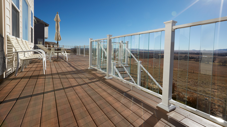 A Fortress FE26 Glass Baluster railing lets in the breeze to cool down a sunny deck