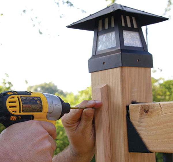 A piece of Acorn Wire Concealing Trim covers up a lighting wire that powers a lit post cap
