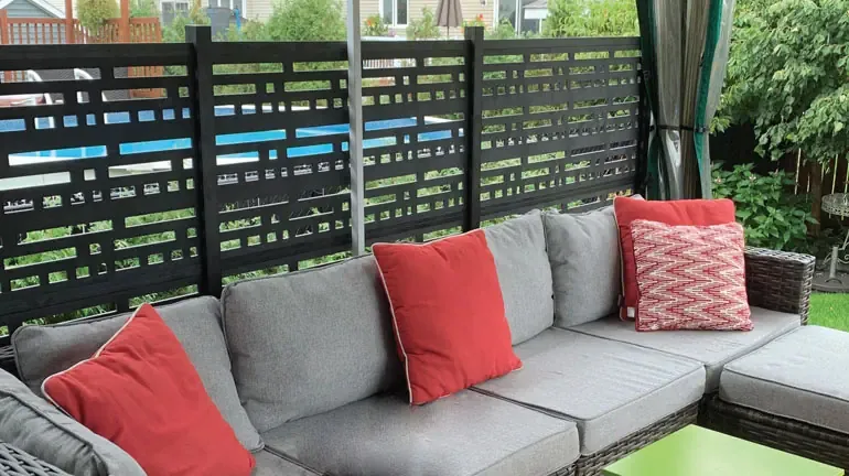 A beautiful outdoor couch with privacy railing behind it