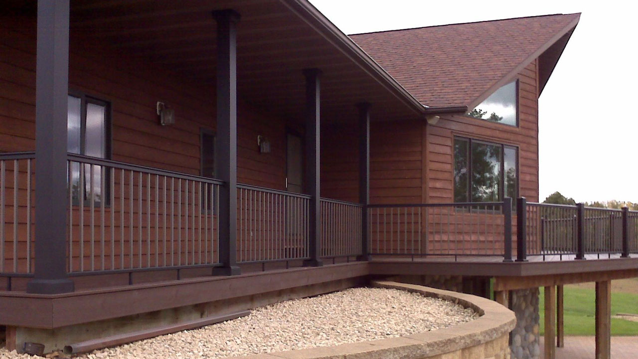 A sleek black finish makes for a classy poch column next to dark brown siding