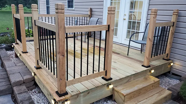 A sturdy wood deck railing with each post fastened securely using a metal post anchor