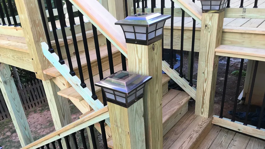 Two solar post cap lights on a set of deck stairs