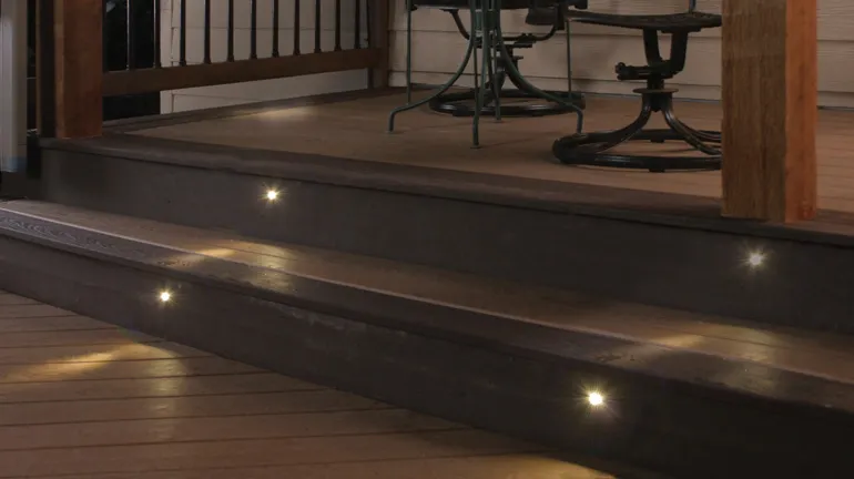 A set of safe deck stairs at night with recessed stair lighting installed into the risers