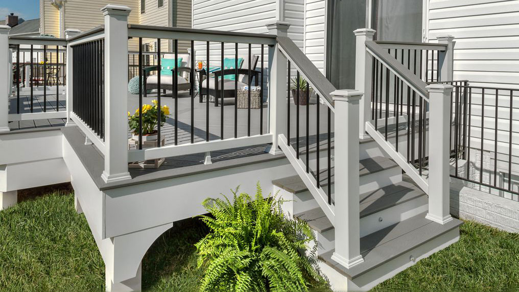 A deck railing planned around a short set of stairs that also have railing