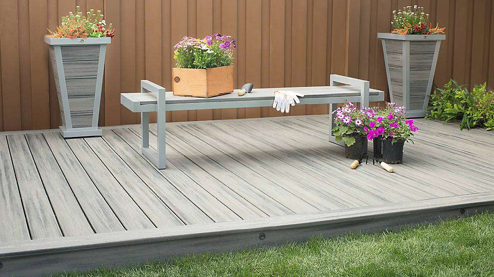 Gray decking, like this Trex Transcend in Island Mist, keeps your deck cooler in direct sunlight - a perfect setting for beautiful flowerpots.