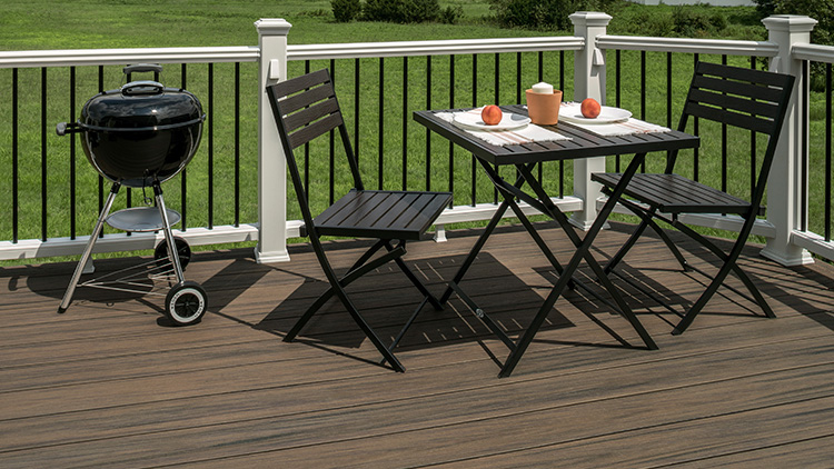 A Trex Enhance deck with charcoal grill and table
