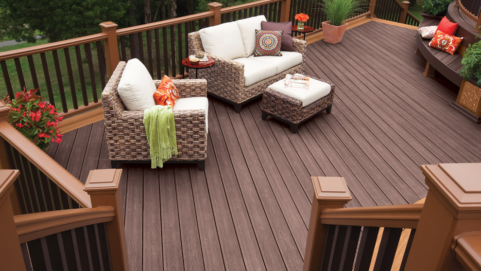 A brown Trex deck using a light brown picture frame and lighter brown railing