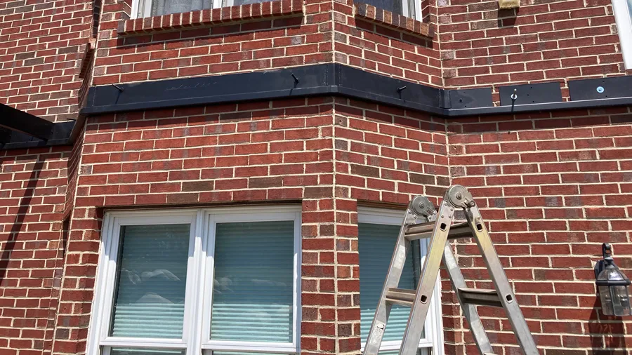 Steel ledger board attached to brick siding